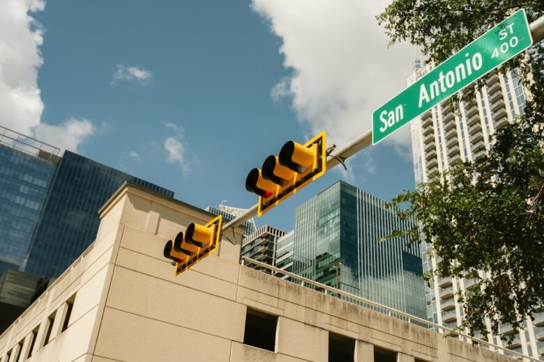 San Antonio street sign and traffic lights with downtown buildings behind