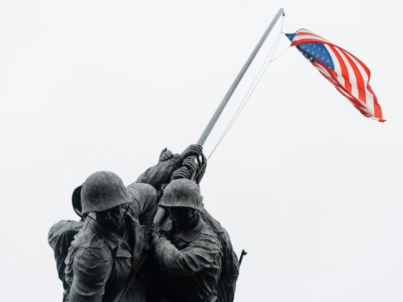 Two soldiers holding an American flag on a hilltop